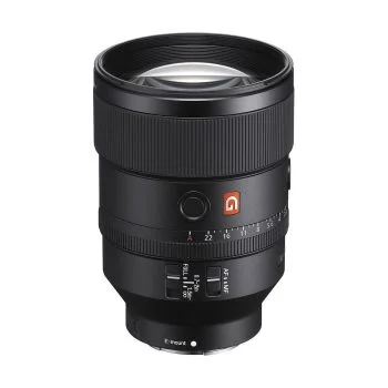 Musta Sony FE 135mm f/1.8 GM -objektiivi, jossa on automaattitarkennuksen ja manuaalitarkennuksen kytkimet, tarkennusrengas ja etäisyyden osoitin, on pystyssä valkoista taustaa vasten.
