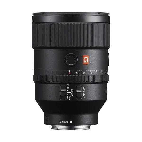 Sony FE 135mm f/1.8 GM -objektiivi, jossa on useita säätökytkimiä, tarkennusrengas ja punainen G-logo sivussa, näkyy mustana valkoista taustaa vasten.