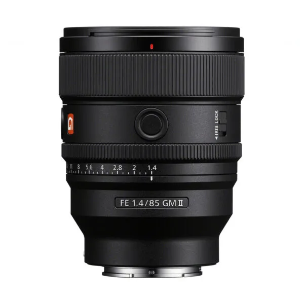 Sony FE 85mm f/1.4 GM II -objektiivi seisoo pystyasennossa valkoisella taustalla, ja sen musta muotoilu, tuotemerkin logo, tarkennusrengas ja aukon merkinnät näkyvät.