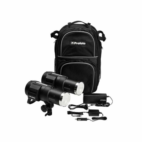 Profoto B1X 500 AirTTL Location Kit, joka sisältää kaksi mustaa kompaktia studiovaloa, virtajohdot, adapterit ja lisävarusteet, on sijoitettu mustan repun eteen valkoiselle taustalle.