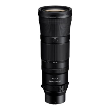 Nikon Nikkor Z 180-600mm f/5.6-6.3 VR -telezoom-objektiivi, musta, seisoo pystyasennossa valkoista taustaa vasten, ja siinä on kuvioidut pitorenkaat ja valkoiset polttovälin merkinnät.