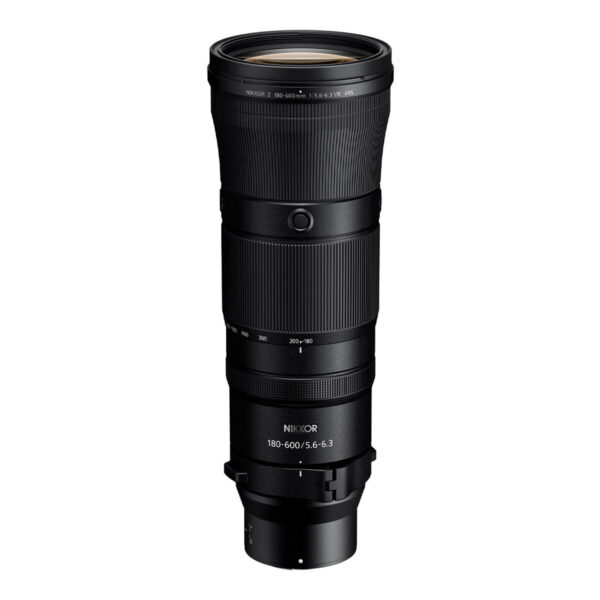 Nikon Nikkor Z 180-600mm f/5.6-6.3 VR -telezoom-objektiivi, musta, seisoo pystyasennossa valkoista taustaa vasten, ja siinä on kuvioidut pitorenkaat ja valkoiset polttovälin merkinnät.