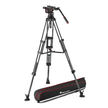 Manfrotto MVTTWINMC kolmijalka Nitrotech N12 -videopäällä seisoo täysin ojennettuna kolmella tukevalla jalalla, joissa on kahva, ja sen alla lattialla lepää musta ja punainen kantolaukku.