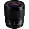 Panasonic Lumix S 18mm f/1.8 -kameran musta objektiivi seisoo pystyasennossa valkoisella pohjalla korostaen sen etulasia ja uurrettua tarkennusrengasta.