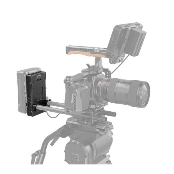 SmallRig 3203 V Mount -akkusovitinlevy, jossa on kaksi 15 mm:n sauvakiinnikettä, on asennettu ammattilaiskameralaitteistoon, jossa on näyttö, suuri objektiivi ja akkupaketti metallikiskoilla jalustan päällä valkoista taustaa vasten.