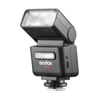 Godox-salamasarjassa IT32 TLL Nikon, kuvassa kulmassa, on säädettävä pää, läpikuultava salaman suojus, ohjauspainikkeet ja kiinnitysjalka kameraan kiinnittämistä varten.