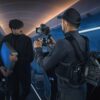 DJI Ronin 4D Flex -laitteella kuvaaja kuvaa miestä, joka kantaa sinistä matkalaukkua tyhjässä lentokoneen matkustamossa, jota valaisee sininen valaistus.