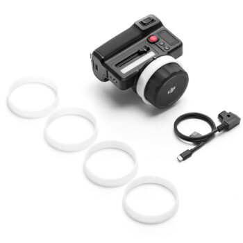 DJI Focus Pro Hand Unit, musta elektroninen kameran lisävaruste, jossa on suuri säätöpyörä, neljä valkoista muovirengasta ja musta USB-C-kaapeli sovittimella, näkyy valkoisella pohjalla.