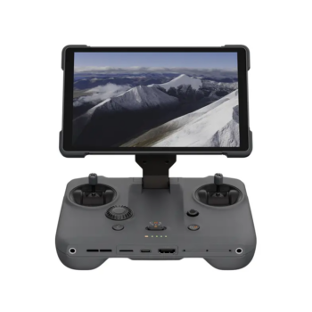 DJI RC Pro 2 -ohjain on harmaa lennokin kauko-ohjain, jossa on kaksi joystickiä, useita painikkeita ja asennettu näyttö, jossa näkyy ilmakuva lumisista vuorenhuipuista pilvisen taivaan alla.